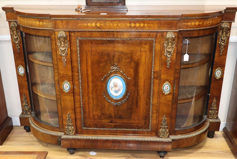 A Victorian ormolu mounted marquetry inlaid walnut credenza, inset with Sevres style porcelain plaques, the central panelled door flank